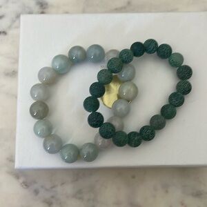 A Jade bracelet along a cute textured bracelet. Both green as seen in pictures